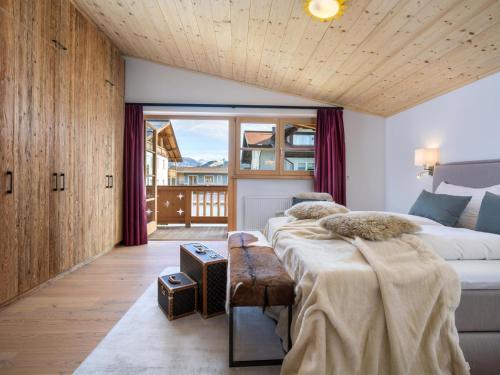 a bedroom with two beds and a large window at Luxury Central Kirchberg in Kirchberg in Tirol
