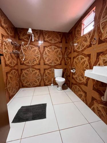 a bathroom with a toilet and wooden walls at aconchego da serra in Coronel José Diaz