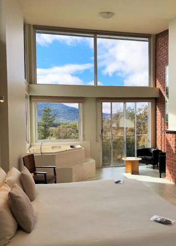 a bedroom with a large bed and a large window at Macedon Ranges Hotel & Spa in Macedon
