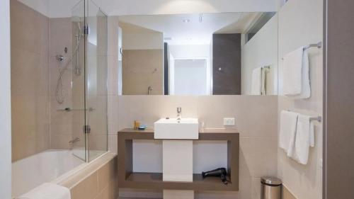 a bathroom with a sink and a shower and a tub at Resort Apartment 275 in Torquay