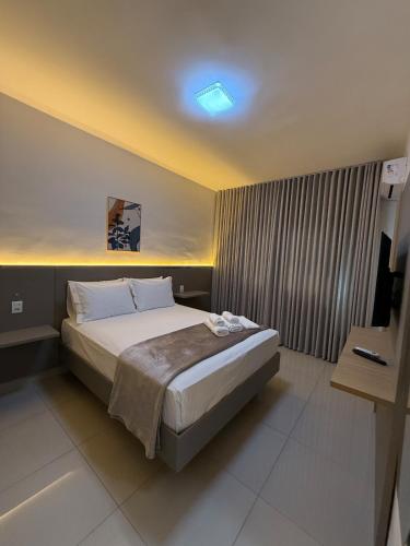 a bedroom with a bed and a television in it at Apto Mais Decor in Salinas