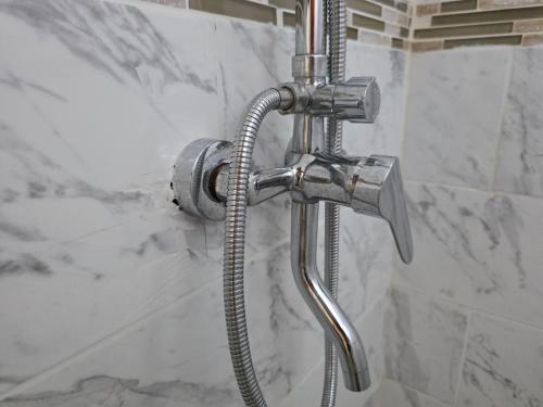 a shower head in a bathroom next to a shower at Penthouse Suite - Chez Mango Villa in Olveston