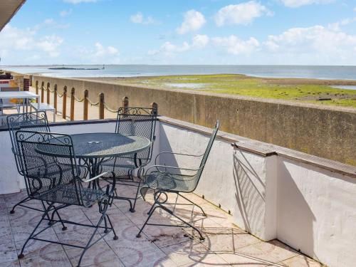 a balcony with a table and chairs and the ocean at Angie's Beachside House in Saint Osyth