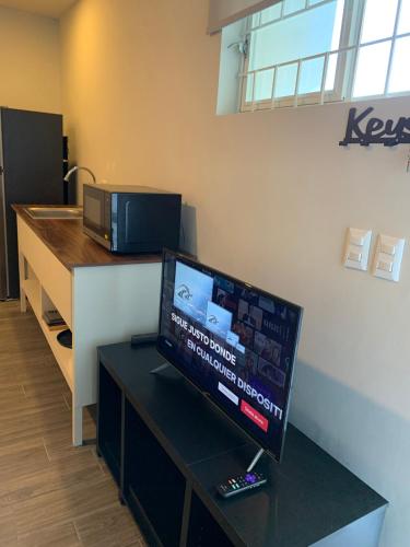 a room with a tv on a table with a counter at LAZARO E - In the heart of San Pedro in Monterrey