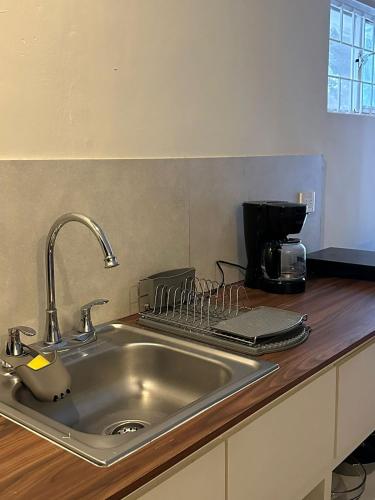 a kitchen counter with a sink and a coffee maker at LAZARO E - In the heart of San Pedro in Monterrey