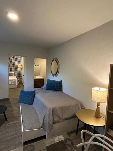 a bedroom with a bed and a table and a mirror at LAZARO E - In the heart of San Pedro in Monterrey