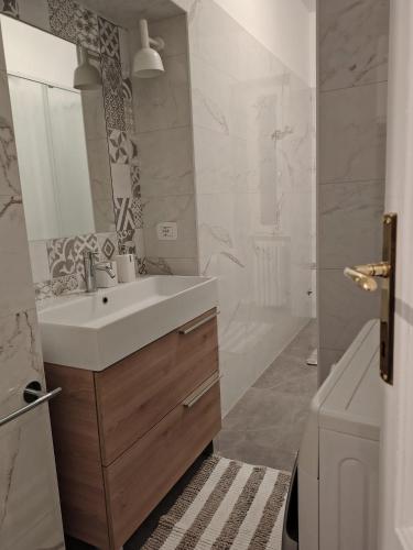 a white bathroom with a sink and a shower at Lacasabianca guest house saronno in Saronno