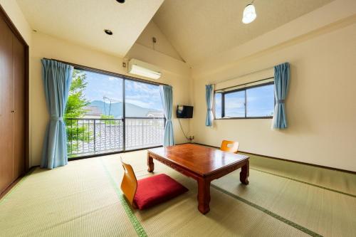 a living room with a table and a large window at Koto no Kashin in Yufu