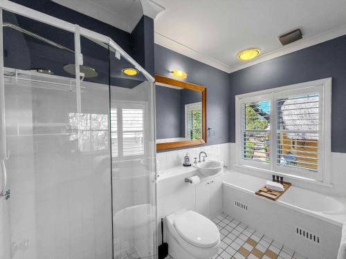 a bathroom with a shower and a toilet and a sink at Villa Remana in Pokolbin