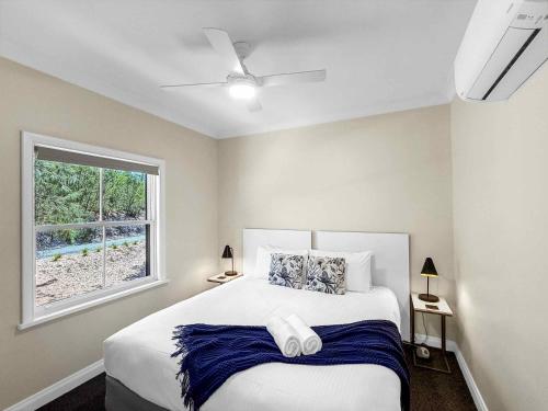 a bedroom with a large bed with a window at Villa Remana in Pokolbin