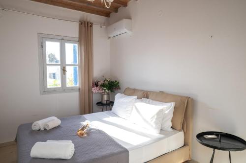 a bedroom with a bed with towels and a window at Mykonos Town Aura Panorama with Private Terrace in Megali Ammos