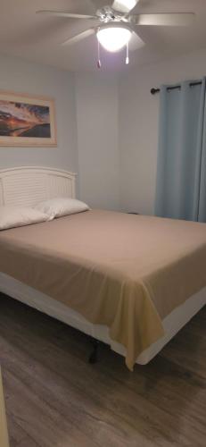 a bed in a room with a ceiling fan at Champagne Island Resort Unit 107 in Wildwood