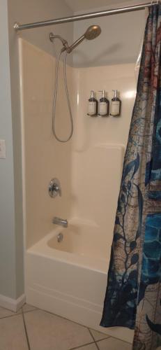 a bathroom with a bath tub with a shower at Champagne Island Resort Unit 107 in Wildwood