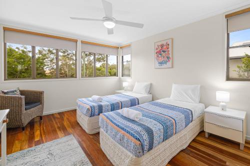 two beds in a room with windows at Yulunga 20 in Mooloolaba