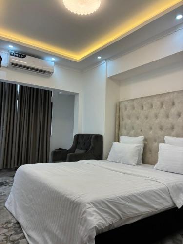 a bedroom with a large white bed and a chair at vk-appart in Maianga