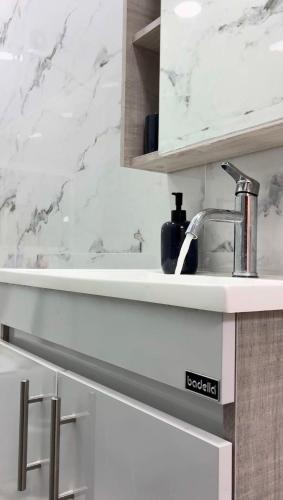 a white kitchen with a sink and a counter at vk-appart in Maianga