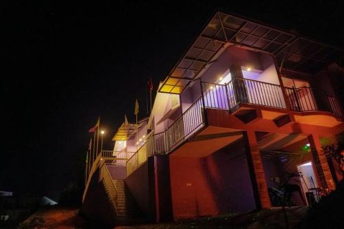 a building with a lit up facade at night at Aikara cottages in Vagamon