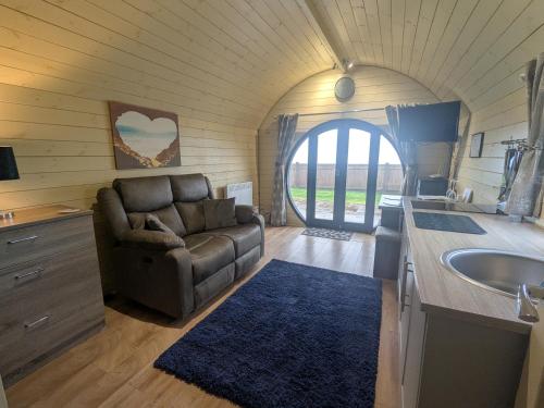 a living room with a couch and a sink at Stapeley Pod in Shrewsbury