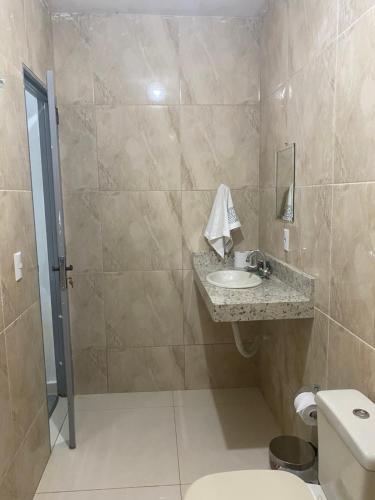 a bathroom with a sink and a toilet at Suítes Goiabal in Pirenópolis