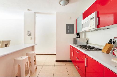 a kitchen with red cabinets and a white counter top at Departamento en condominio Diamante Turquesa in Acapulco
