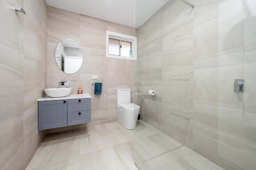 a bathroom with a toilet and a sink and a mirror at 3Bed 2Bath home - Nth Central Reno metres from Hosp w Wifi in Shepparton