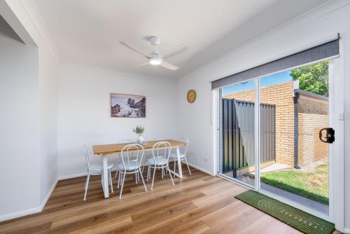 a dining room with a table and chairs and a large window at 3Bed 2Bath home - Nth Central Reno metres from Hosp w Wifi in Shepparton