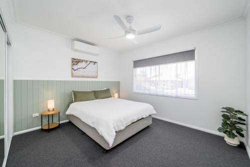 a white bedroom with a bed and a window at 3Bed 2Bath home - Nth Central Reno metres from Hosp w Wifi in Shepparton