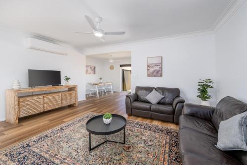 a living room with a couch and a tv at 3Bed 2Bath home - Nth Central Reno metres from Hosp w Wifi in Shepparton