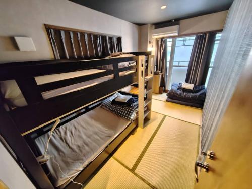 two bunk beds in a room with a window at Sakae Guesthouse in Nagoya