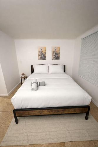 a bedroom with a large bed with white sheets at Ariia Fort Lauderdale Airport in Fort Lauderdale