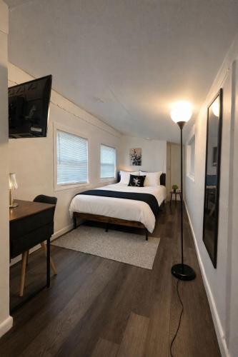 a bedroom with a bed and a desk and a television at Ariia Fort Lauderdale Airport in Fort Lauderdale