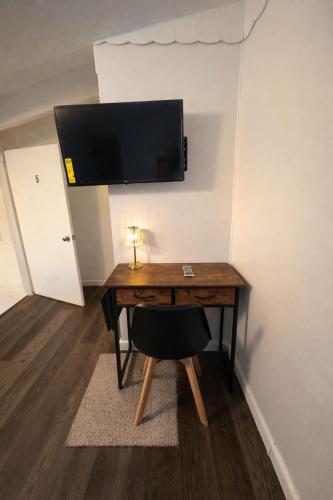 a desk with a flat screen tv on a wall at Ariia Fort Lauderdale Airport in Fort Lauderdale