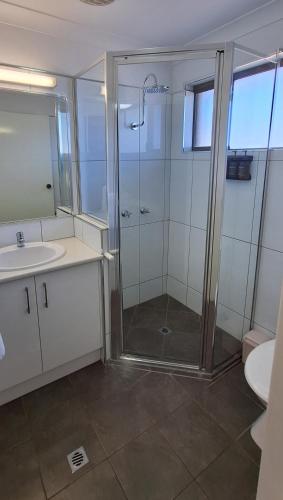 a bathroom with a shower and a sink at Macintyre Motor Inn in Goondiwindi