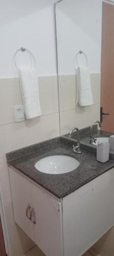 a bathroom counter with a sink and a mirror at Casa condomínio in Maceió