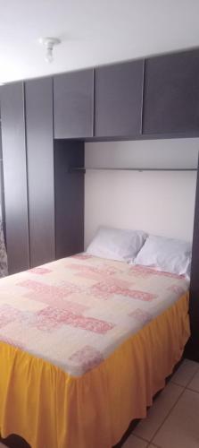a bedroom with a large bed with a yellow blanket at Casa condomínio in Maceió