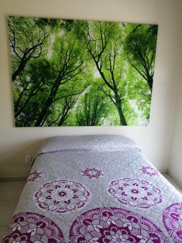 a bedroom with a bed with a picture of trees at VENECIA APARTMENT, Excellent Location in Tepic