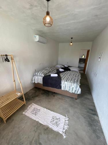 a bedroom with a bed and two rugs in it at Suite Adam 3 em Caraíva com piscina 900m da Vila in Caraíva