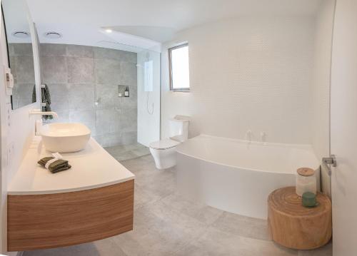 a bathroom with a tub and a sink and a toilet at McNeil Luxury Studio in Wanaka