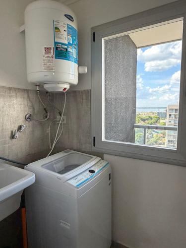 a washing machine in a bathroom with a window at Torre Aymara 8C in Posadas