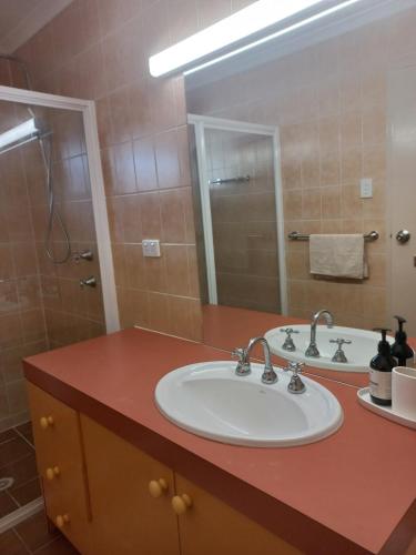 a bathroom with a sink and a mirror at Peaceful and private two bedroom unit in Alice Springs