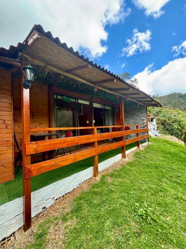 a house with a wooden fence in front of it at Hotel Cerro Fuerte breakfast & eventos in Sopó