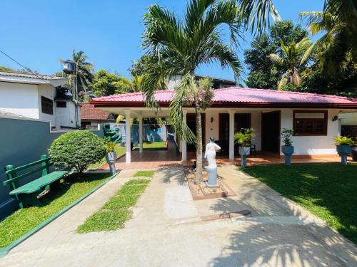 a house with a fire hydrant in front of it at Madu Villa in Weligama