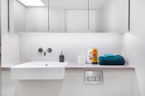 a white bathroom with a sink and a mirror at Modern Stratford Westfield Olympic Village 1 Bedroom Apartment in London