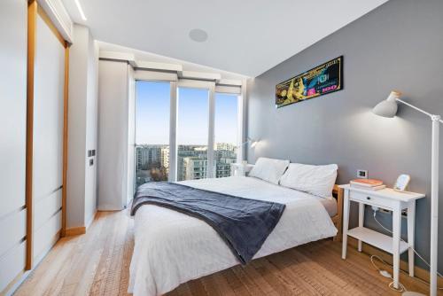 a bedroom with a bed and a large window at Modern Stratford Westfield Olympic Village 1 Bedroom Apartment in London