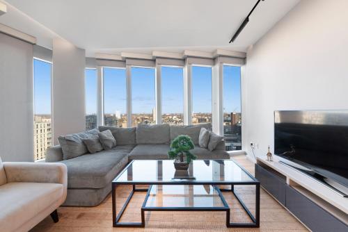 a living room with a couch and a tv at Modern Stratford Westfield Olympic Village 1 Bedroom Apartment in London