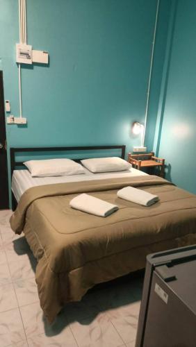 a bedroom with a bed with two towels on it at 99Hostel&Bar Koh Chang in Ko Chang