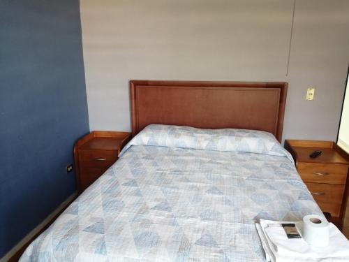 a bedroom with a bed with a wooden head board at Ciudad del Valle Departamento C in Tepic