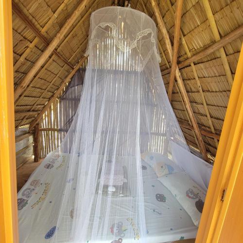 a bed in a tent with a mosquito net at Island Crib in El Nido