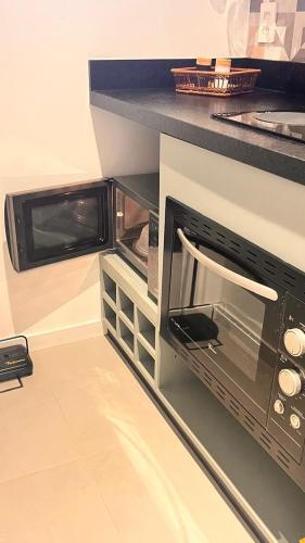 a microwave oven sitting on top of a counter at Pousada Studio Siriú in Garopaba