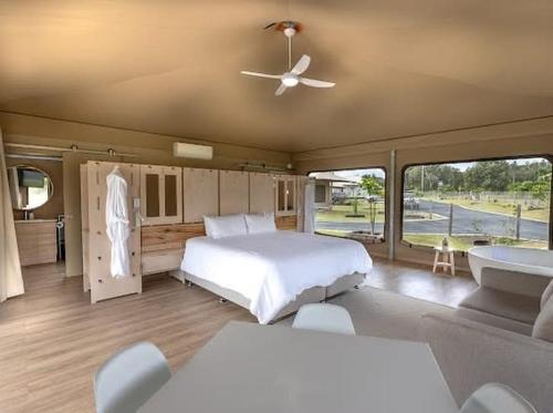 a bedroom with a large bed and a large window at Crowdy Bay Eco Resort in Harrington